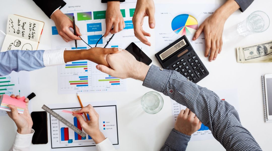 Picture of businessmen’s hands on white table with documents and drafts Picture of businessmen's hands on white table with documents, coffee and drafts